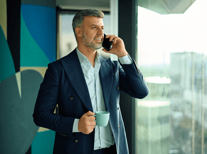 Öltönyben dolgozó vállalkozó telefonál